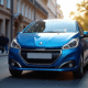 Voiture Peugeot 208 bleue en ville en journée