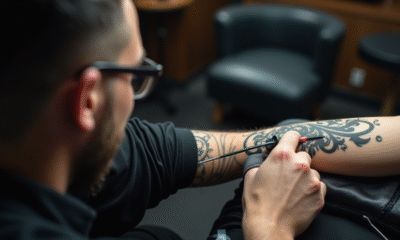Tatoueur appliquant un tatouage tribal noir sur le bras