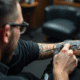 Tatoueur appliquant un tatouage tribal noir sur le bras
