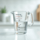 Verre mesure eau de 150 ml sur plan de travail blanc
