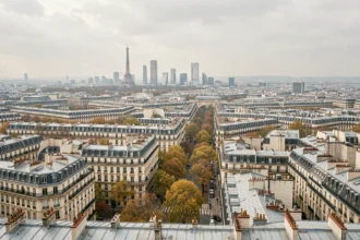 Vue aérienne panoramique de Paris montrant la densité urbaine et les monuments emblématiques comme la Tour Eiffel et La Défense